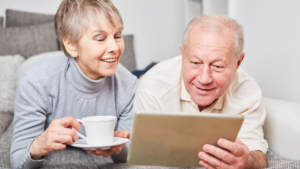 an elderly couple checking their digital tablets